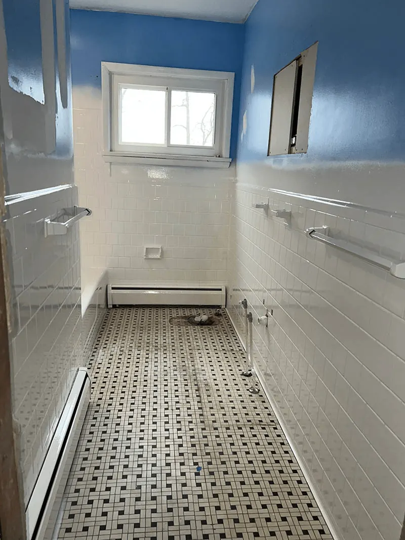Bathroom painted blue with white tile wainscot